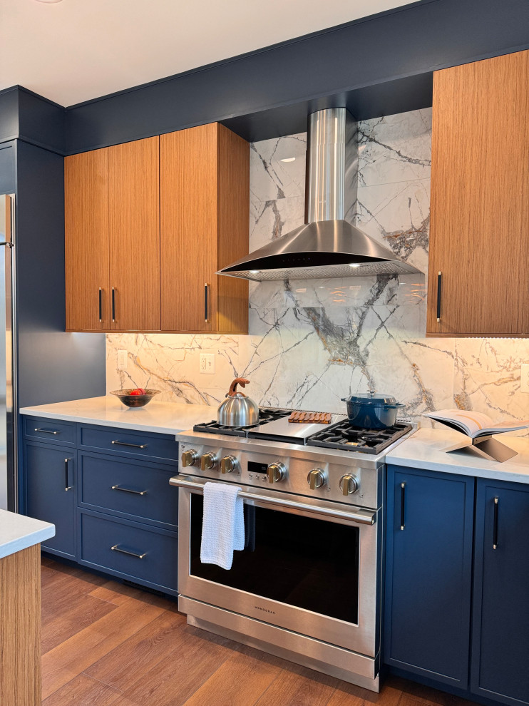 Modern kitchen with earth tone cabinets: wood-faced uppers and blue lower cabinets,